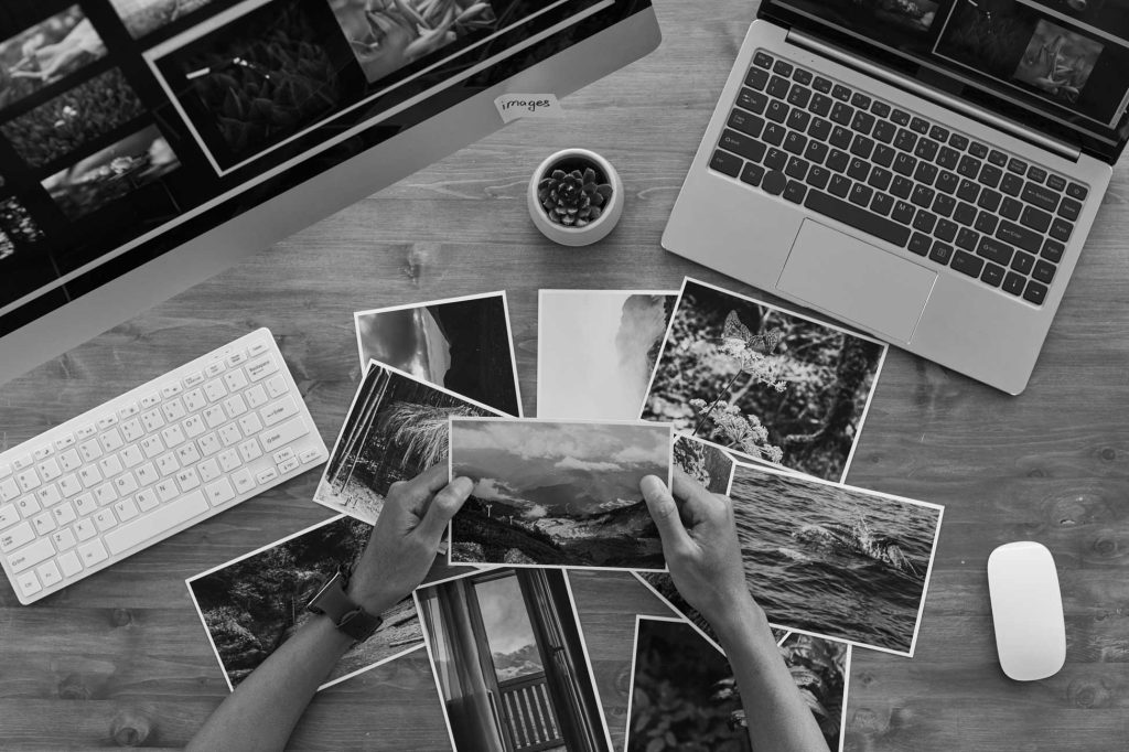 travel photographer holding pictures top view DXJLBWM